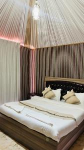 Un dormitorio con una cama grande en una tienda de campaña. en Sunlight camp, en Wadi Rum