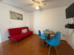 a living room with a red couch and a table and chairs at Casa Balam Cayo Lobo in Cancún