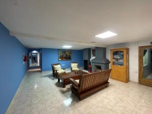 a living room with blue walls and a table and chairs at Hostel Danny in El Calafate