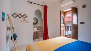 a bedroom with a bed and a door with a window at Riad L'EncensOriental in Marrakech