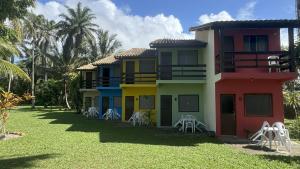 a colorful house with chairs in front of it at Hotel Mamoan in Ilhéus