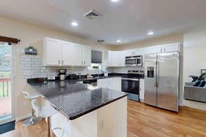 a kitchen with white cabinets and a stainless steel refrigerator at Pocono Waterside Escape in Tobyhanna