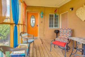 eine Veranda mit Stühlen und einer orangefarbenen Tür in der Unterkunft New Mexico Cottage Hot Springs Fed Tub On-Site in Truth or Consequences
