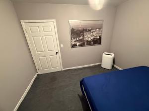 a bedroom with a blue bed and a painting on the wall at Private room in guest house - Mini Mansion in Burbank
