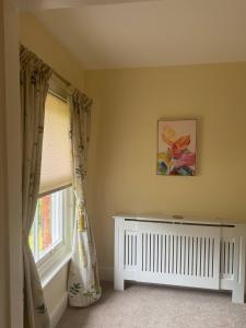 a room with a window with curtains and a crib at Red House in Hinton +7 photos