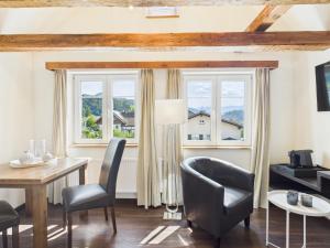 Una sala de estar con mesa y sillas y ventanas. en S'Matt, en Feldkirch
