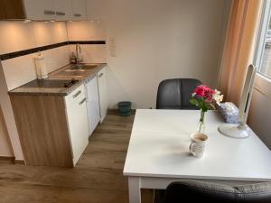 a kitchen with a table with a vase of flowers on it at Gemütliches und komfortables Studio in Frankfurt in Frankfurt