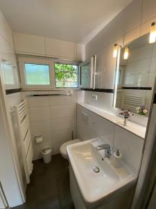 a white bathroom with a sink and a toilet at Gemütliches und komfortables Studio in Frankfurt in Frankfurt