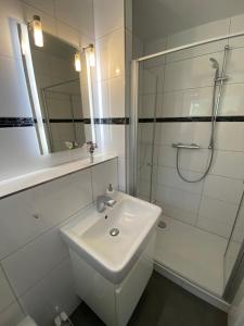 a white bathroom with a sink and a shower at Gemütliches und komfortables Studio in Frankfurt in Frankfurt
