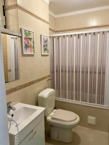 a bathroom with a white toilet and a sink at Typical Nazaré House in Nazaré