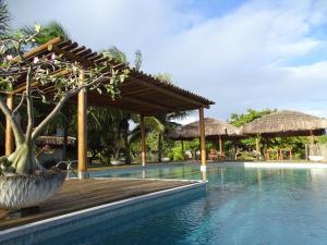 a swimming pool with a wooden deck and a resort at Casa Corveta in São Miguel do Gostoso