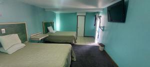 a hotel room with two beds and a television at Motel la siesta in Tijuana