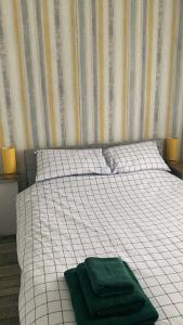 a bed with two green towels on top of it at Sherman The Chalet in Withernsea