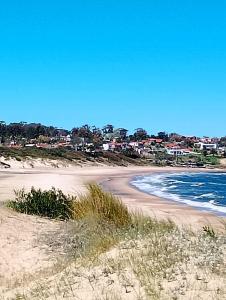 a sandy beach with a town in the background at Relax by the sea in Piriápolis