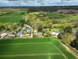 an aerial view of a house in a green field at Foxglove Cottage in Bransgore