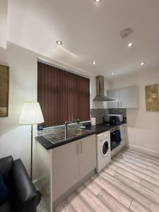 a kitchen with a sink and a washing machine at Stylish Studio Apartment in Leicester