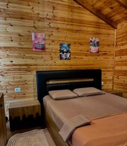 a bedroom with a bed in a wooden wall at Sancho Farm Albania in Memaliaj