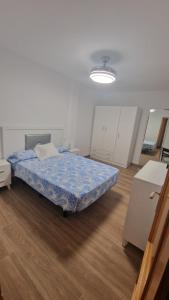 a bedroom with a bed in a white room at Alojamiento Paco Cabrera 3C Reformado in Almuñécar
