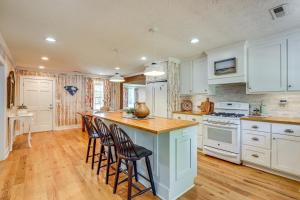 eine Küche mit weißen Schränken und eine Insel mit Barhockern in der Unterkunft 3 Mi to Beach Pawleys Island Cottage in True Blue