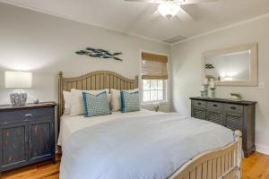 ein Schlafzimmer mit einem großen Bett mit blauen Kissen in der Unterkunft 3 Mi to Beach Pawleys Island Cottage in True Blue
