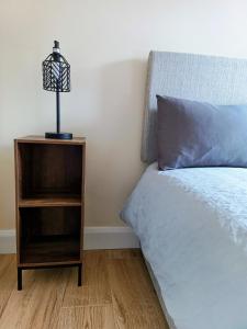 a bedroom with a bed and a night stand with a lamp at City Centre C Apartment, Parking, Ground Floor in Belfast