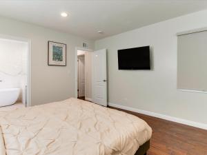 a bedroom with a bed and a television on the wall at Woodland Hills Zen Modern in Woodland Hills +29 photos