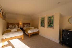 a bedroom with two beds and a dresser at Hobbs Cottage in Hinton
