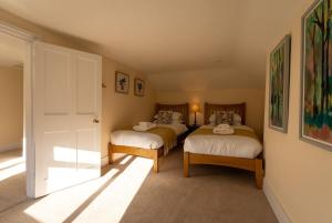 a bedroom with two beds and a door with a window at Hobbs Cottage in Hinton