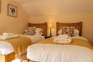 a bedroom with two beds with towels on them at Hobbs Cottage in Hinton +35 photos