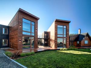 a modern house with large windows and a yard at Luna Llena Dina Huapi in Dina Huapi
