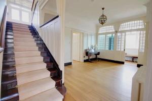 a staircase in a home with white walls and wood floors at Arnewood Manor in Sway