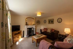 a living room with a couch and a fireplace at Rose cottage in Bransgore +27 photos