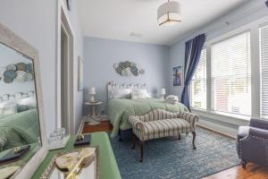 a bedroom with two green beds and a mirror at The Margaret Suite at The Abbey House a B&B in Daytona Beach in Daytona Beach
