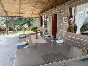 a long table with plates and glasses on a patio at Posada Rural Aguita de Panela in La Vega
