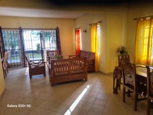 a living room with chairs and tables and windows at Jugroop Beach House in Baie du Tombeau +13 photos