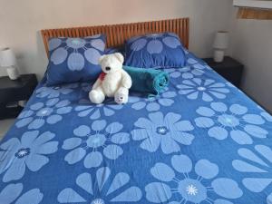 a teddy bear sitting on top of a bed at Perle de la côte in Menton