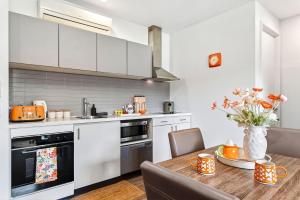 a kitchen with white cabinets and a wooden table at 1BR Apartment 43 sleeps 5,Golf,Beach,Hot Springs in Fingal +4 photos