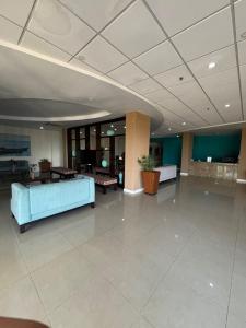 Un gran vestíbulo con un sofá azul y mesas. en CASA PORS Beach Front Apartment with security, pool &jacuzzi, en Portmore 22 fotos más