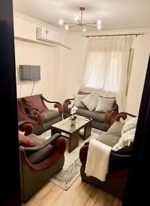 a living room with couches and a table at Spacious 2BR Apt 2BA Gated Community in Sheikh Zayed +22 photos