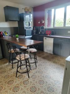 a kitchen with a wooden table and four chairs at Chambre a 5 min de Center Parc bois aux daims in Les-Trois-Moutiers