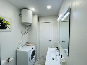 a bathroom with a washing machine and a sink at Apartamento con piscina y balcón recién reformado in Platja  d'Aro