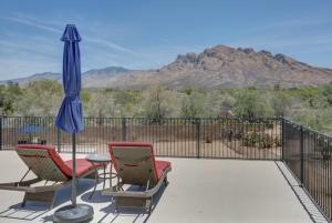 a patio with two chairs and an umbrella and a table at Oro Valley Guest House with Roof Top Views in Oro Valley