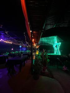 a restaurant with tables and lights at night at Estrella verde Lodge in Pejibaye