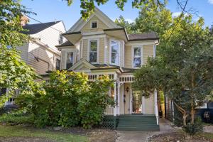 an old house with a green porch on a street at Spacious Historic House Near Louisville Sites in Louisville