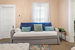 a couch with blue pillows in a living room at Spacious Historic House Near Louisville Sites in Louisville