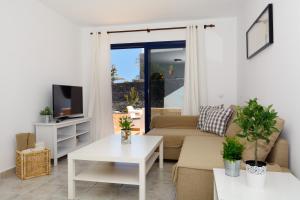 sala de estar con sofá y mesa en Villa Oasis, en Playa Blanca