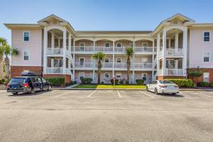 Un gran edificio con coches aparcados en un estacionamiento. en Golf Getaway by Casino, Dolphin Cruises and Beach!, en Little River