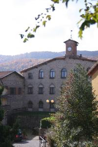 a large building with a clock tower on top of it at Hotel Ristorante Giardino in Abbadia San Salvatore