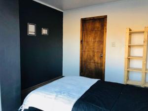 GualliguaicaにあるCasa de Montaña en Puclaro, Valle de Elquiのベッドルーム1室(ベッド1台付)、木製のドア