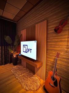 a living room with a guitar and a television at Loft Apartments in Duhok